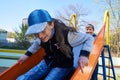 Children play on the playground next to a condominium. Swing, slide, stairs, multistory building. A place for children to play.