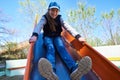 Children play on the playground next to a condominium. Swing, slide, stairs, multistory building. A place for children to play.