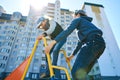 Children play on the playground next to a condominium. Swing, slide, stairs, multistory building. A place for children to play.