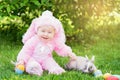 Children play with real rabbit. Laughing child at Easter egg hunt with pet bunny