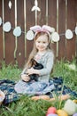 Children play with real rabbit. Laughing child at Easter egg hunt with white pet bunny. Little toddler girl playing with animal in Royalty Free Stock Photo