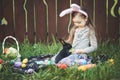 Children play with real rabbit. Laughing child at Easter egg hunt with white pet bunny. Little toddler girl playing with animal in Royalty Free Stock Photo