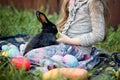 Children play with real rabbit. Laughing child at Easter egg hunt with white pet bunny. Little toddler girl playing with animal in Royalty Free Stock Photo