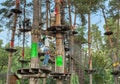 Children play in the rope park among the forest. Child in the forest adventure park. Children in protective helmets walk
