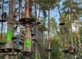 Children play in the rope park among the forest. Child in the forest adventure park. Children in protective helmets walk