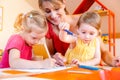 Children and play school teacher drawing together Royalty Free Stock Photo