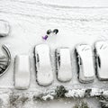 Children play in snow around cars in parking lot Royalty Free Stock Photo