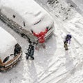 Children play in snow around cars in parking lot Royalty Free Stock Photo