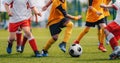 Children Play Soccer Game. Young Boys Running and Kicking Football Ball on Grass Sports Field