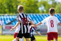 Children play sports. Kids kicking football match. Young boys playing soccer on the green grass pitch. Royalty Free Stock Photo