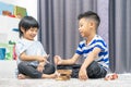 Children play with a toy designer on the floor of the children`s room. Two kids playing with colorful blocks. Kindergarten educati