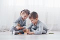 Children play with a toy designer on the floor of the children`s room. Two kids playing with colorful blocks Royalty Free Stock Photo