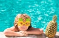 Children play in tropical resort. Little boy child having fun in swimming pool. Summer pineapple fruit. Royalty Free Stock Photo