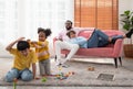 Children play with wooden toy on floor in living room while parent sitting on couch. Two kids playing with colorful blocks Royalty Free Stock Photo