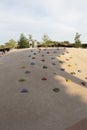 Children playground with climbing wall hand holds bulges, trees, metal pergola in the back. Tyufeleva Roshcha city park, Zilart !m