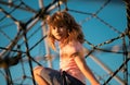 Children playground in urban park. Child climbing the net. Kids play and climb outdoors on sunny summer day. Royalty Free Stock Photo