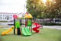 Children playground on yard activitie in public park rounded by green tree at sunlight morning. Royalty Free Stock Photo