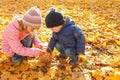 Children playing with autumn fallen leaves in the park Royalty Free Stock Photo