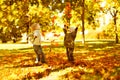 Children playing with autumn fallen leaves in park Royalty Free Stock Photo
