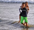 CHILDREN PLAYING AT THE BEACH IN INDONESIA