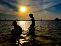 Children playing at the beach, silhouette of young boy playing crazy happy and free at the beach, backlit shot