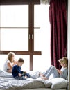 Children playing in bed with their tablets and phones Royalty Free Stock Photo