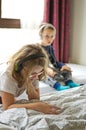 Children playing in bed with their tablets and phones Royalty Free Stock Photo