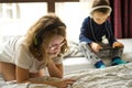 Children playing in bed with their tablets and phones Royalty Free Stock Photo