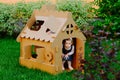 Children are playing in cardboard kid house. Child having fun outdoors. Royalty Free Stock Photo