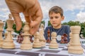 Children playing chess at chessboard outdoors. Boy thinking chess combinations