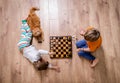 Children playing in chess. Preschool boy and girl play on floor with educational game. Toys for preschool and Royalty Free Stock Photo