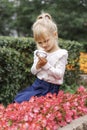 Children playing in the city park looking at flowers with a magnifying glass Royalty Free Stock Photo