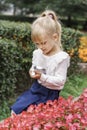 Children playing in the city park looking at flowers with a magnifying glass Royalty Free Stock Photo