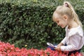 Children playing in the city park looking at flowers with a magnifying glass Royalty Free Stock Photo