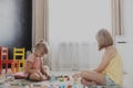 Children playing with toy building blocks on the floor at home or kindergarten Royalty Free Stock Photo