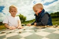 Children playing draughts or checkers board game outdoor Royalty Free Stock Photo