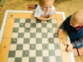 Children playing draughts or checkers board game outdoor Royalty Free Stock Photo