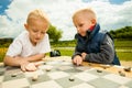 Children playing draughts or checkers board game outdoor Royalty Free Stock Photo
