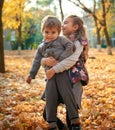 Children are playing on fallen leaves in autumn city park. Royalty Free Stock Photo