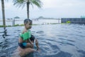 Children playing with father in water pool