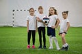 Children playing football indoors. Football team contains four girls