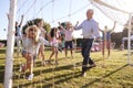 Children Playing Football Match With Adults At Summer Garden Fete