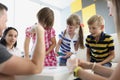 Children playing fun card game with adults, brothers and sisters having fun at home with parents Royalty Free Stock Photo