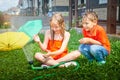 Children playing with garden sprinkler. Brother and sister running and jumping. Summer outdoor water fun in backyard Royalty Free Stock Photo