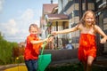 Children playing with garden sprinkler. Brother and sister running and jumping. Summer outdoor water fun in backyard Royalty Free Stock Photo