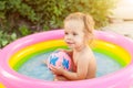 Children playing in inflatable baby pool. Kids swim and splash in colorful round pool Royalty Free Stock Photo