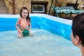 Children playing in the inflatable swimming pool. Siblings having fun in the pool. Summer holidays and vacation concept