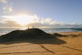 Children playing on large mound of sand on the beach with sunrise in the background at Slade Point, Queensland, Australia Royalty Free Stock Photo