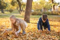 Children playing with leaves in autumn park Royalty Free Stock Photo