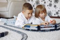 Children playing with lego and toy train in a playing room